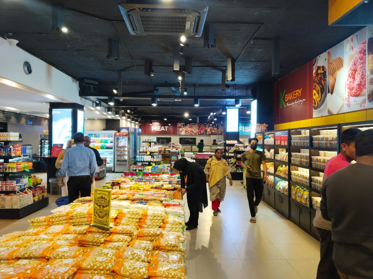 Customers shopping past the meat and bakery counters at Khulshi Mart